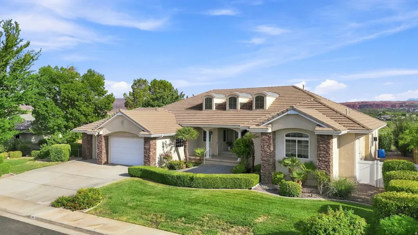 Stone-accented exterior with a tiled roof, multiple dormer windows, and an arched entry