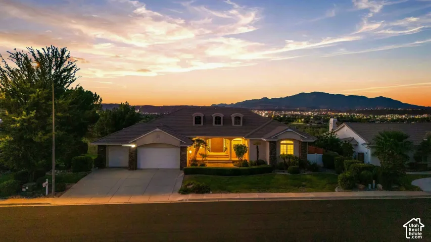 Single-story residence featuring a two-car garage, manicured landscaping, and a paved driveway