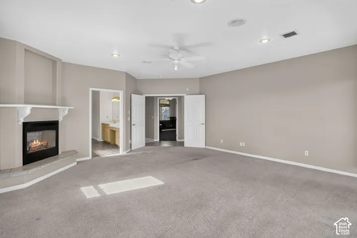Spacious primary living area with neutral wall finishes, ceiling fan, and recessed lighting throughout