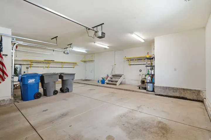 Spacious garage featuring concrete flooring and exposed ceiling beams
