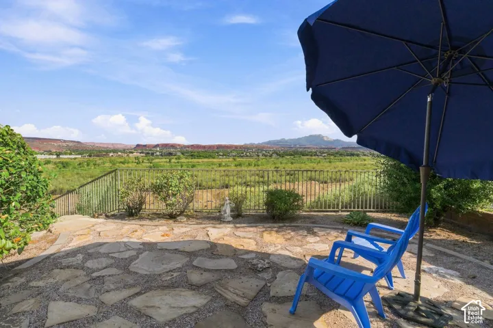 Stone-paved patio with a metal fence and surrounding natural landscape