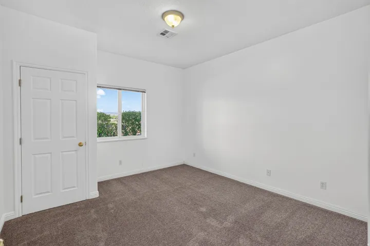 Bright interior with clean white walls, a single-pane window, and carpet flooring