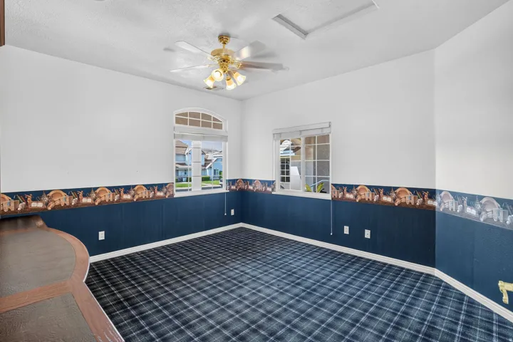 Arch-top window, ceiling fan, tartan pattern carpet, built-in desk, white trim