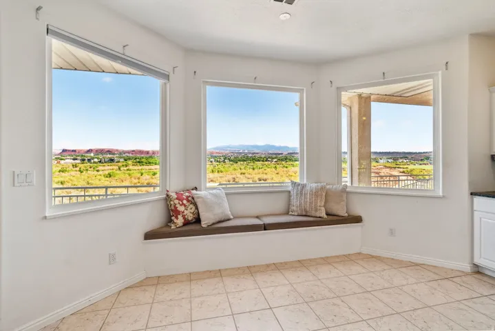 Bright corner room with three large picture windows framing panoramic vistas of rolling hills and open landscape