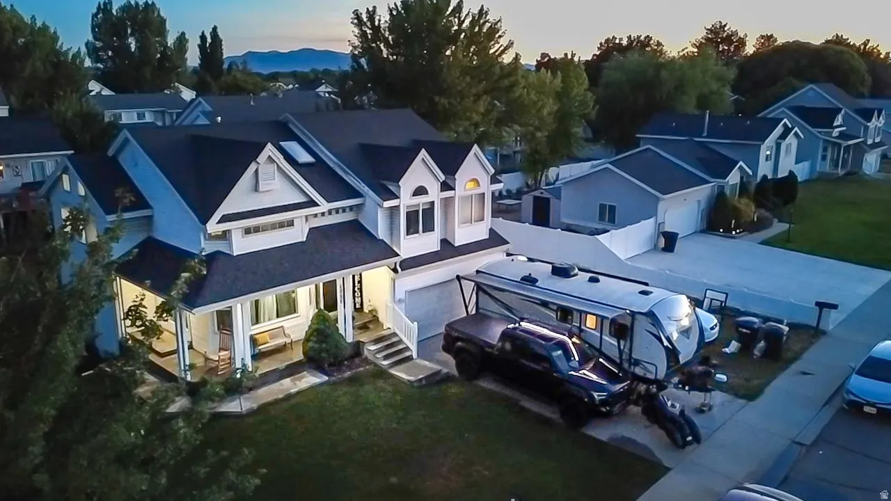 Two-story residence with a covered front porch, an attached garage, and a long driveway