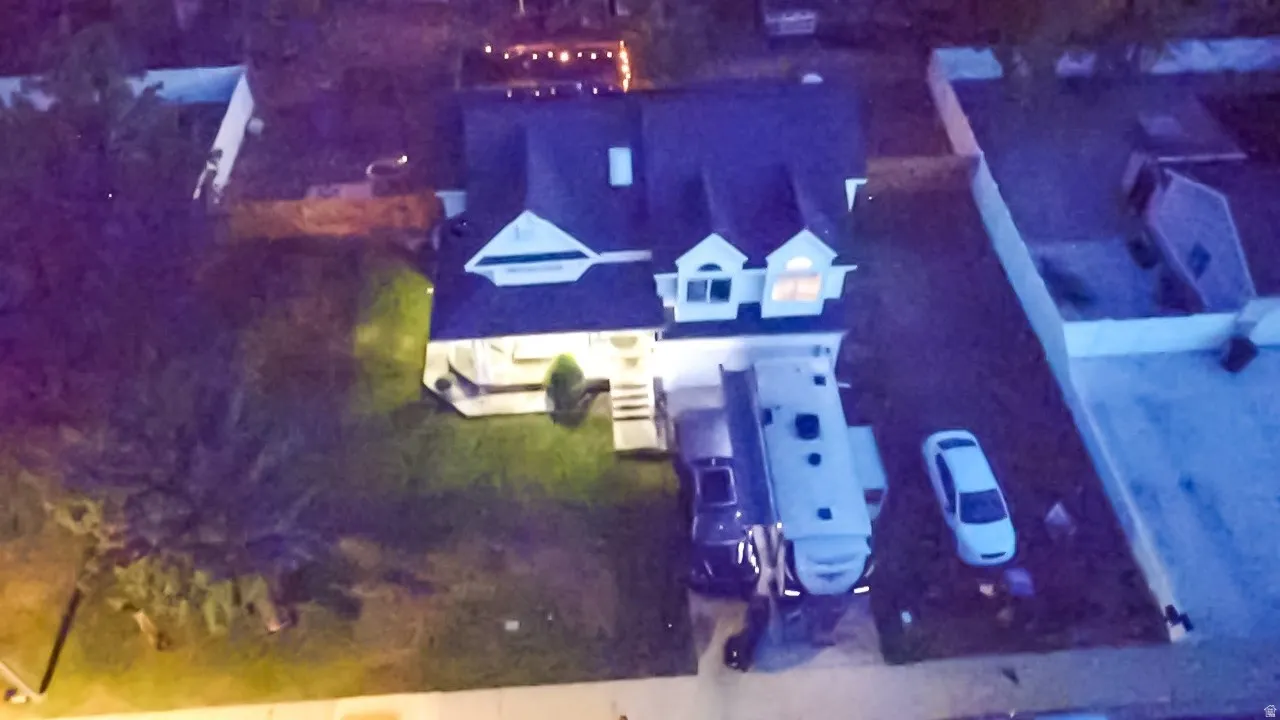 Gabled roofline with multiple dormers, front porch, and expansive front yard