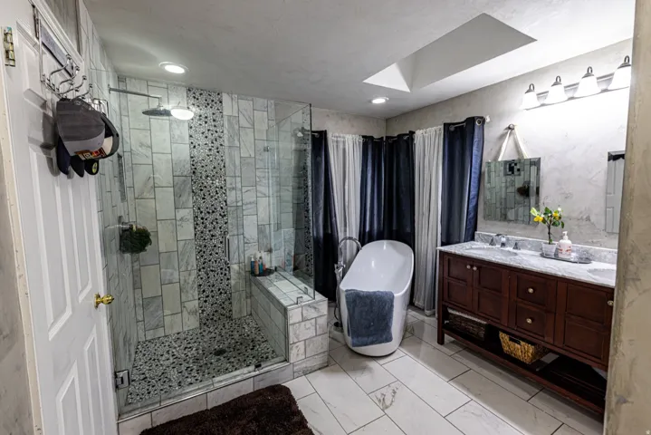 Glass-enclosed shower with a built-in bench and vertical accent tile