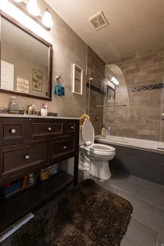 Dark wood-finish vanity with a single basin, framed mirror, and integrated lighting