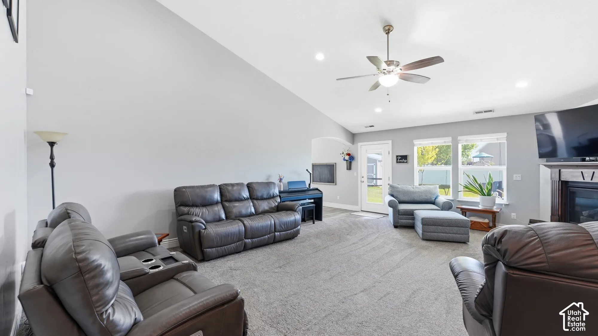 Vaulted ceiling, ceiling fan, recessed lighting, carpeted flooring, and a fireplace with a wood mantel