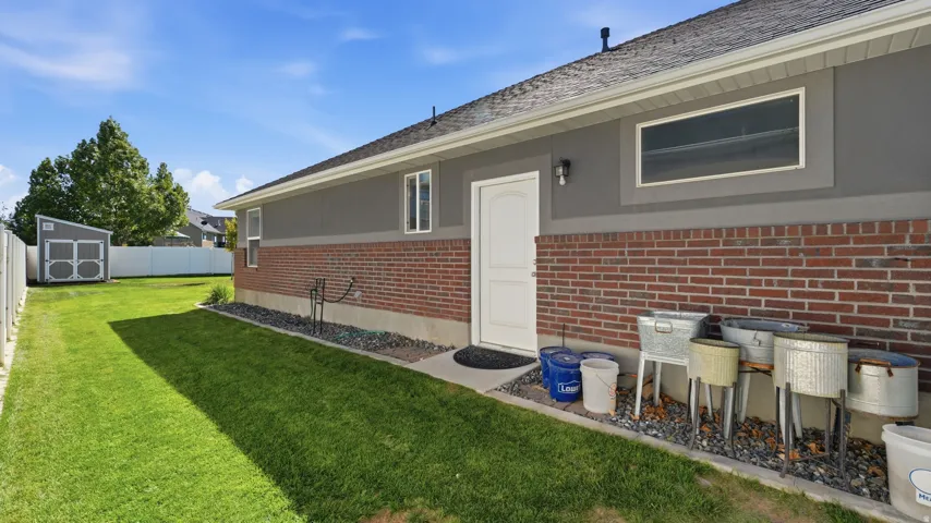 Brick and stucco exterior with multiple windows and a white entry door