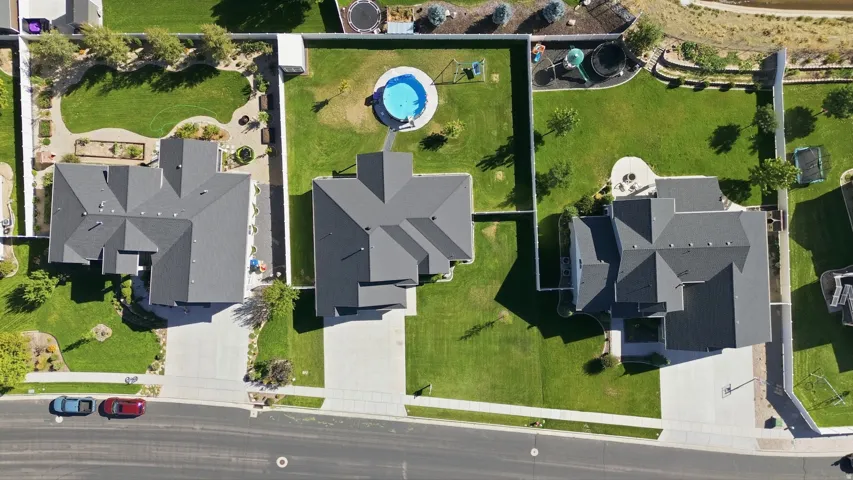 Expansive backyard featuring a manicured lawn, established landscaping, and a fenced perimeter