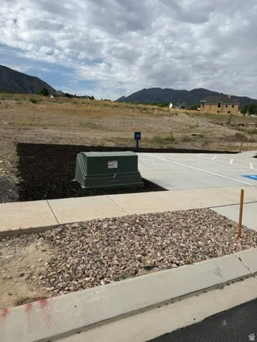 Paved concrete pathway, gravel landscaping, and a mountainous backdrop