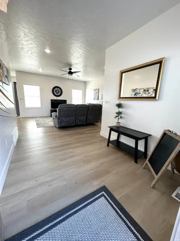 Wood-finish flooring throughout, recessed lighting, and a ceiling fan in the living area