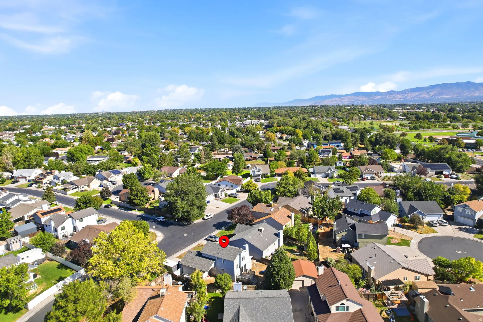 Neighborhood setting with mature trees and mountain backdrop