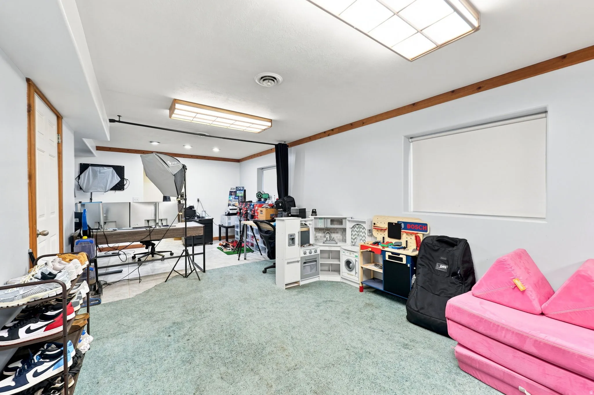 Recessed lighting, wood trim accents, light-colored walls, and carpeting