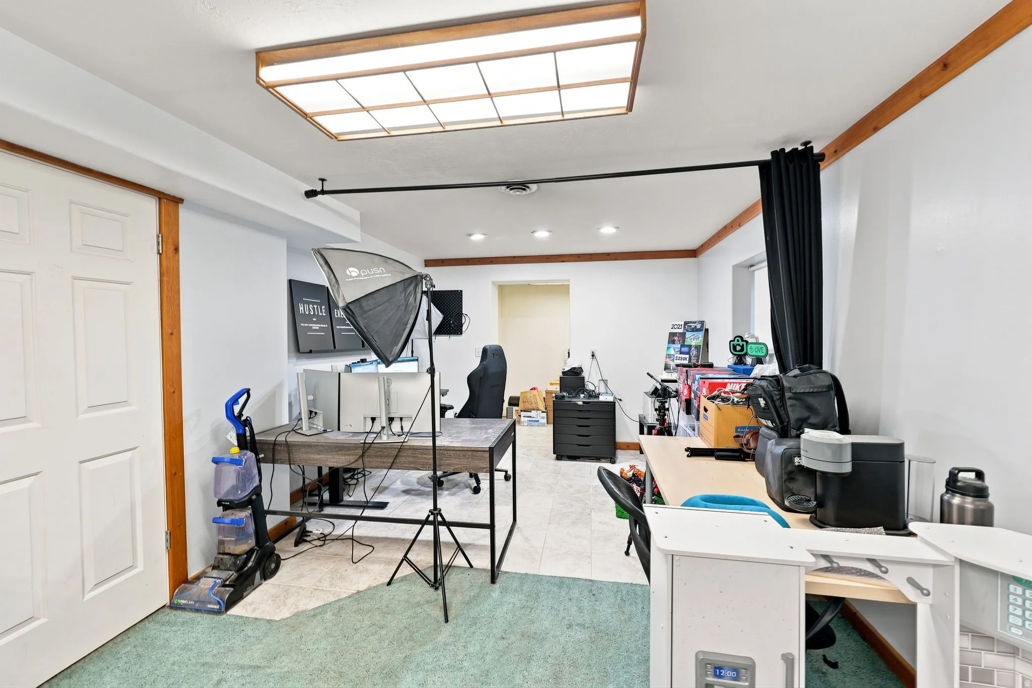 Recessed lighting, wood-finish ceiling trim, and a white paneled door