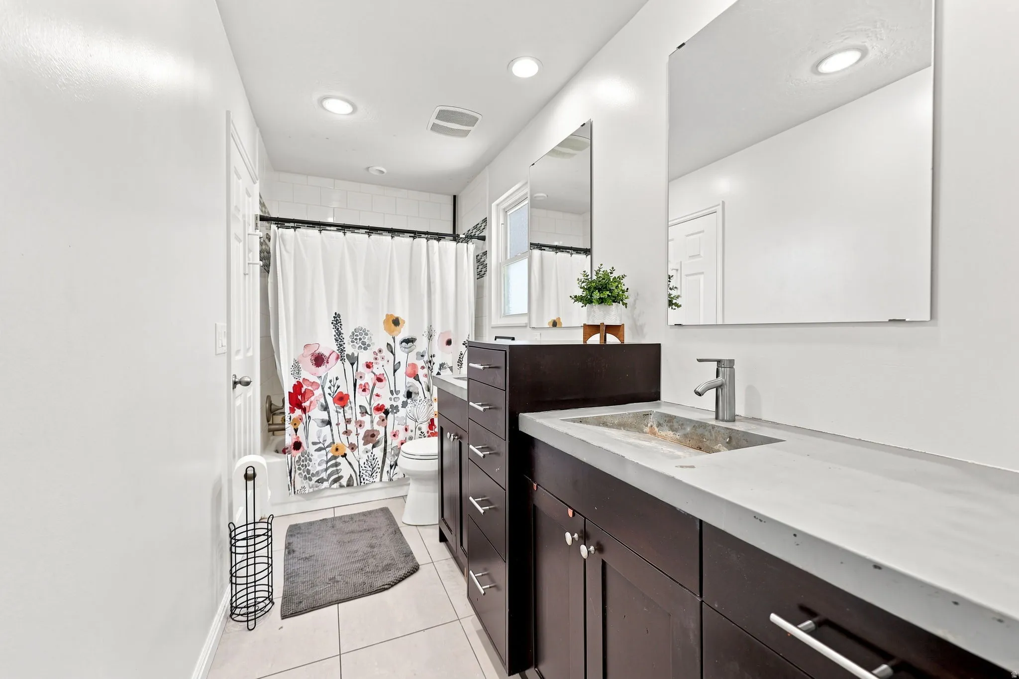 Dark wood-finish vanity with integrated sink, modern chrome faucet, and rectangular mirrors
