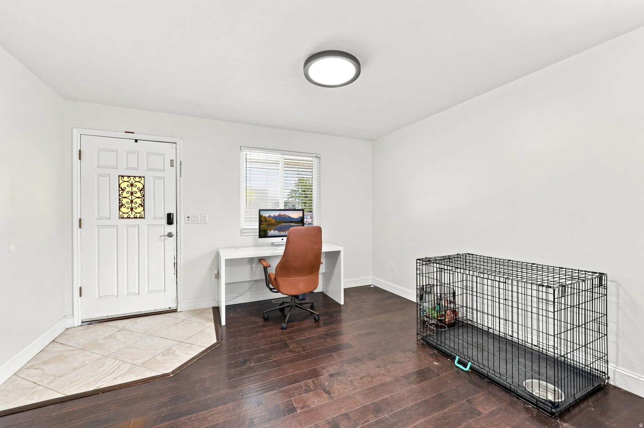 Neutral white walls, dark wood-finish flooring, and a tile entry