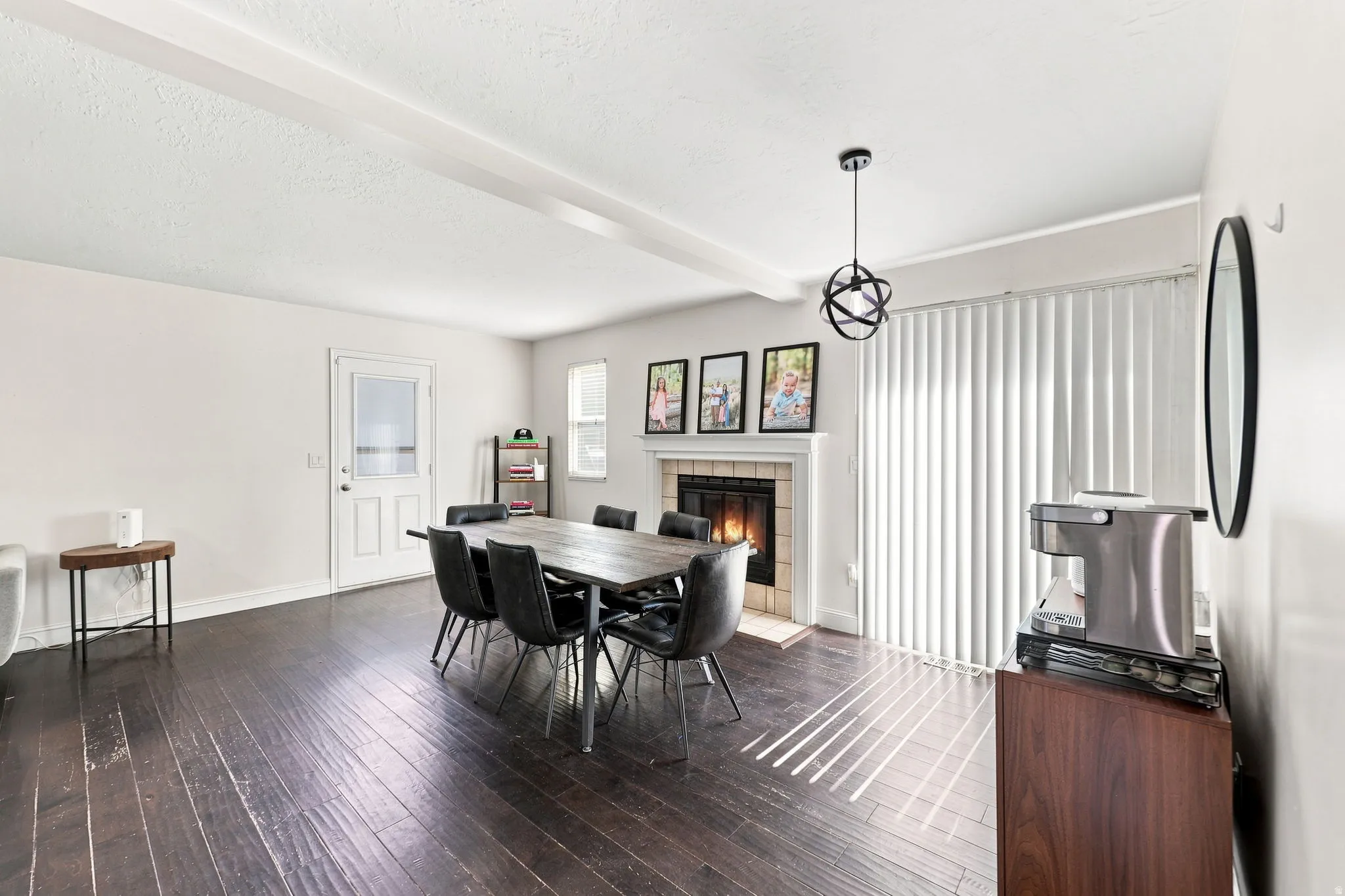 Dark wood-finish flooring with white walls and ceiling beams