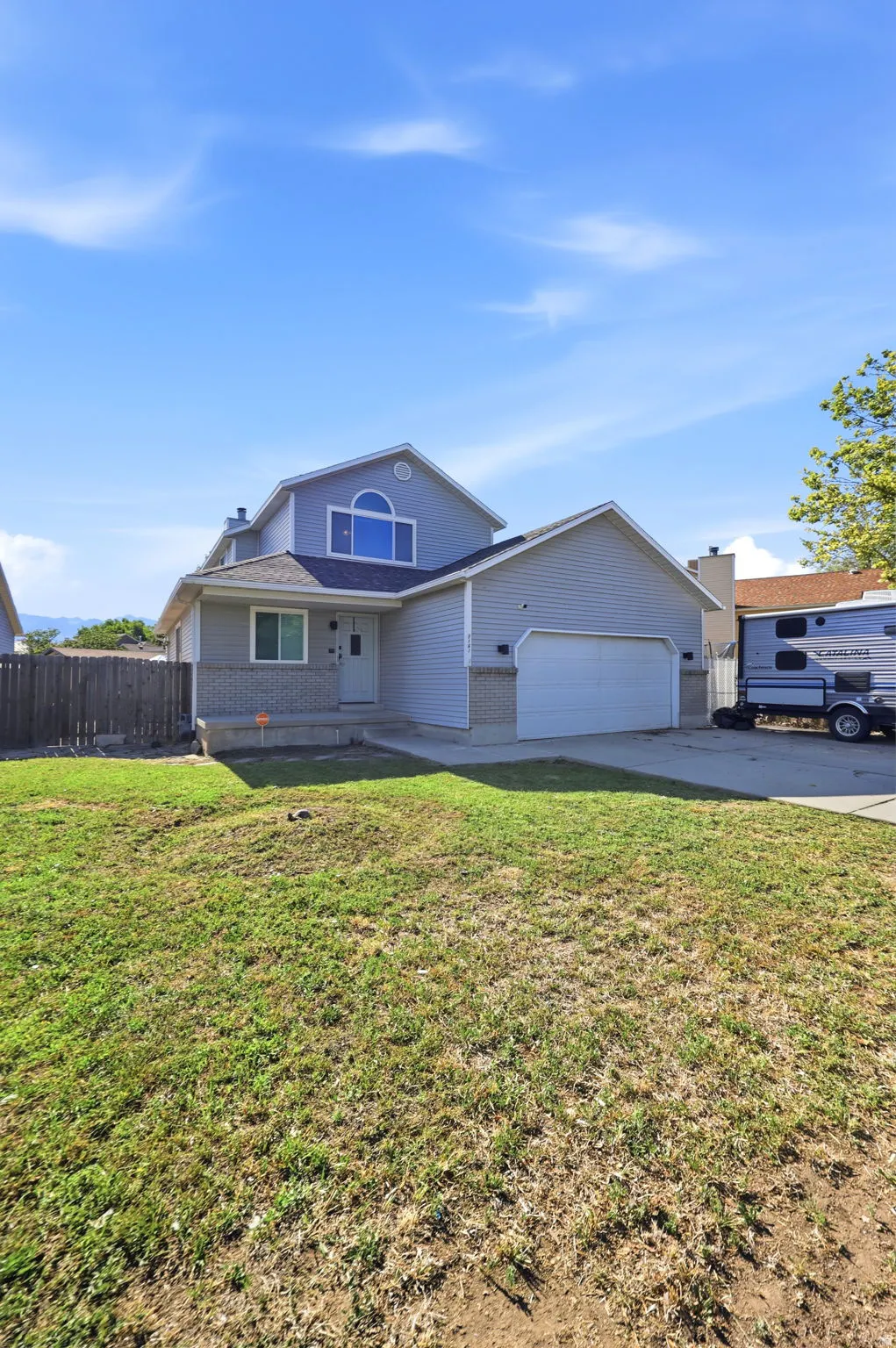 Two-story residence with siding exterior, arched window, and attached two-car garage