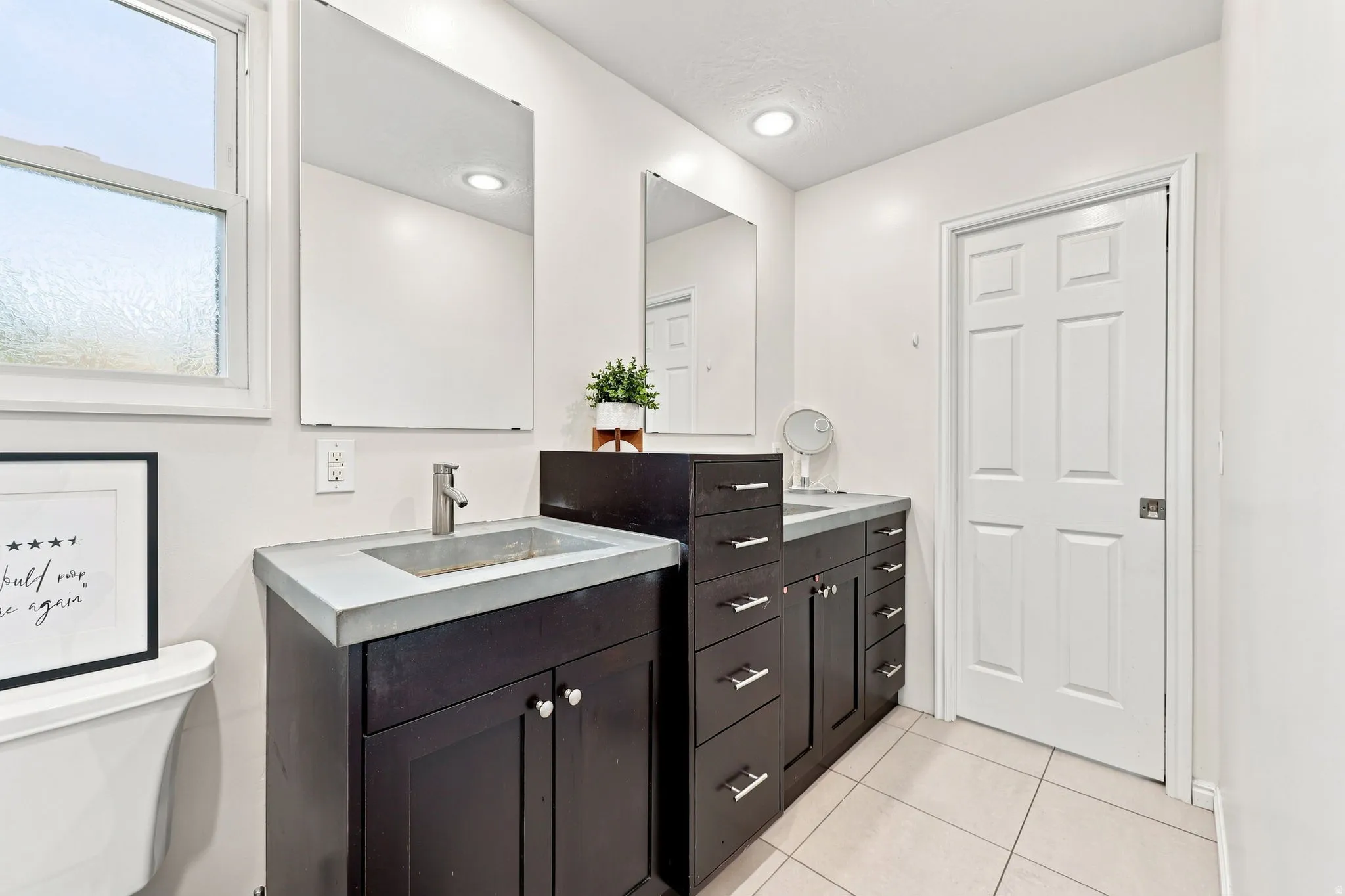 Dual vanity with integrated sinks, dark wood-finish cabinetry, and contemporary wall-mounted mirrors
