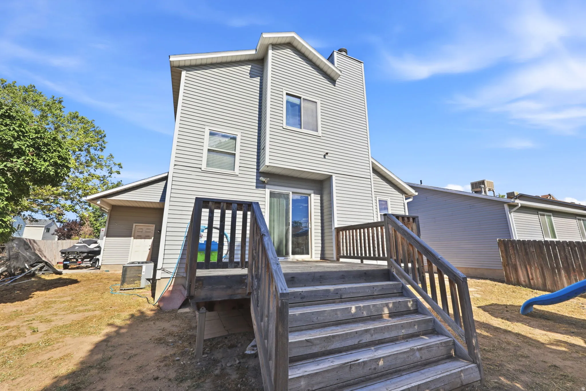 Wood deck with stairs leading to a sliding glass door