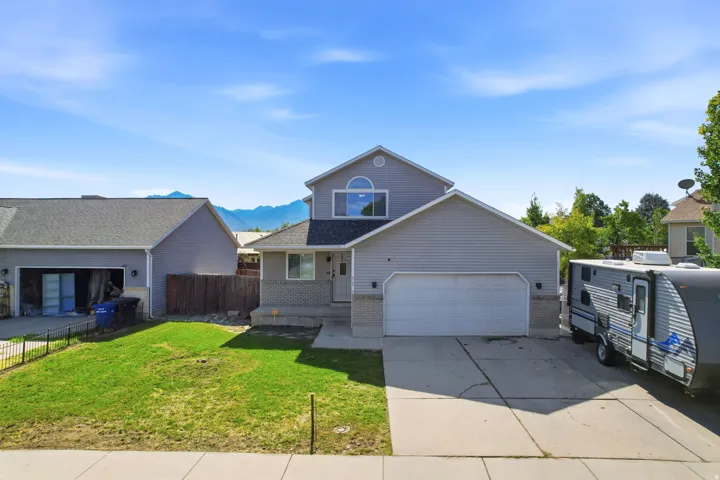 Two-story residence featuring light gray siding, an attached two-car garage, and a concrete driveway