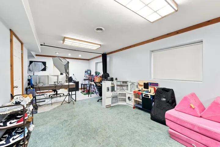 Recessed lighting, wood trim accents, light-colored walls, and carpeting