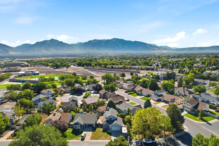 Mountain backdrop with a residential neighborhood featuring established homes, mature trees, and paved streets