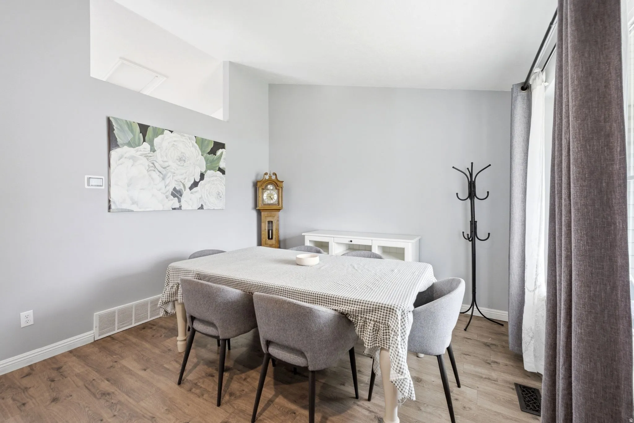 Wood-finish flooring, light gray walls, white baseboards, and a white built-in cabinet