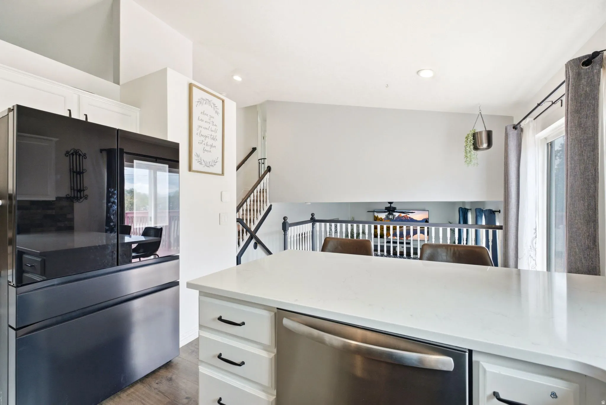 Kitchen island with a light-toned countertop and integrated dishwasher