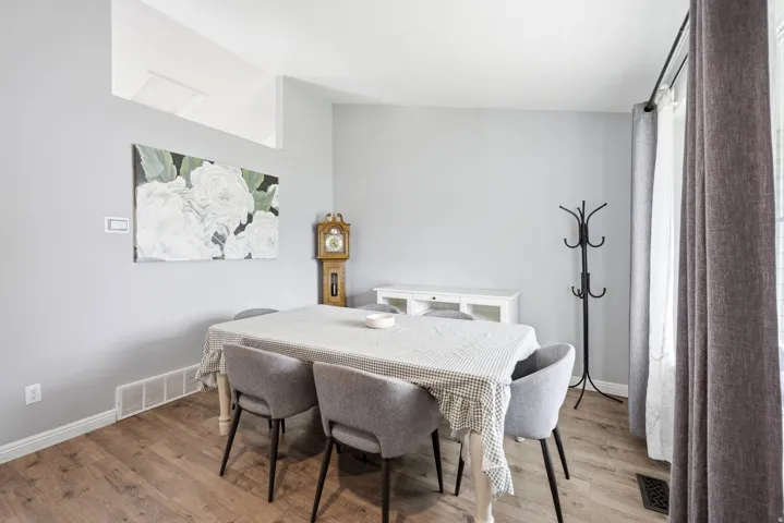 Wood-finish flooring, light gray walls, white baseboards, and a white built-in cabinet