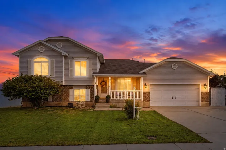 Two-story residence with a two-car garage, front porch, and mature landscaping