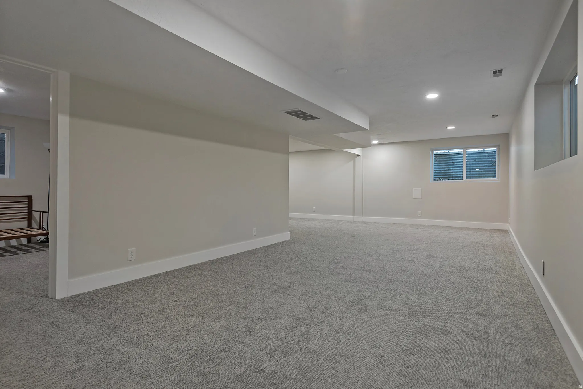 Expansive room featuring light gray carpeting and recessed lighting