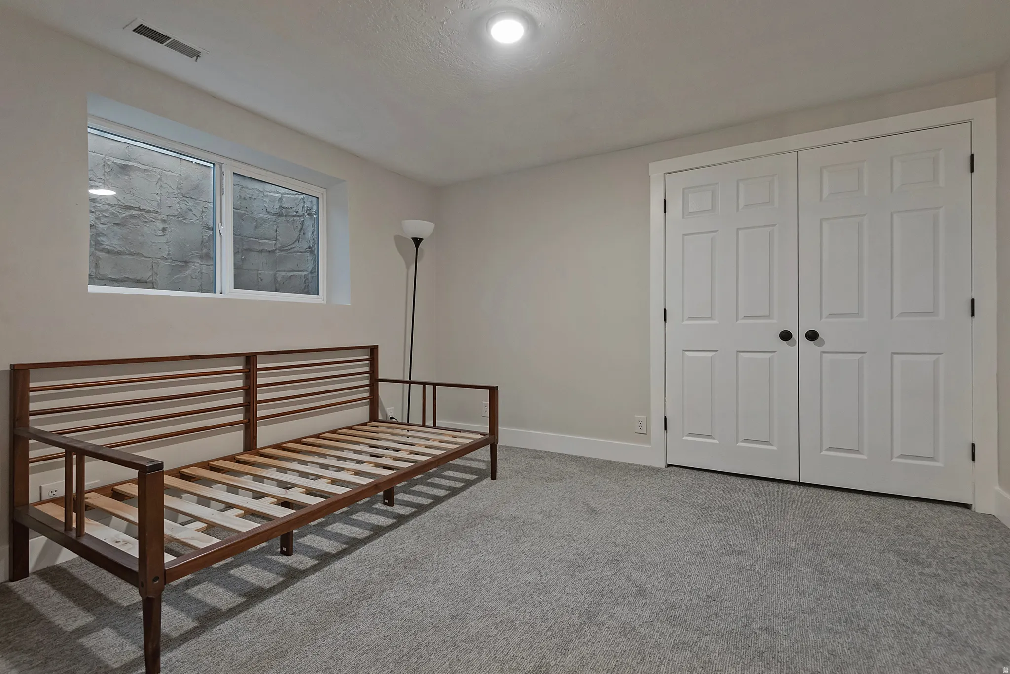 Gray carpeting, white trim, recessed lighting, and a window well