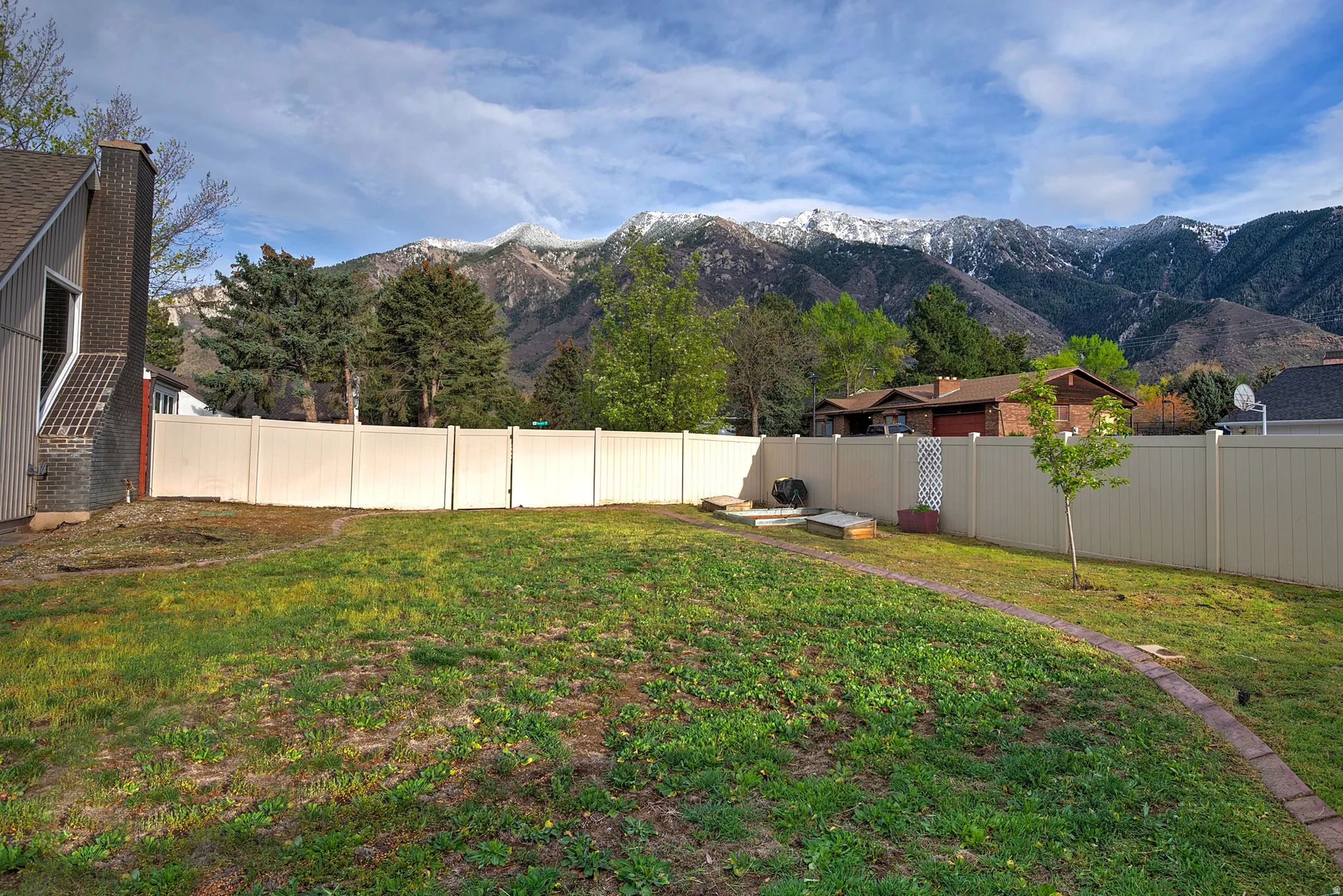 Expansive grass lawn with a full privacy fence