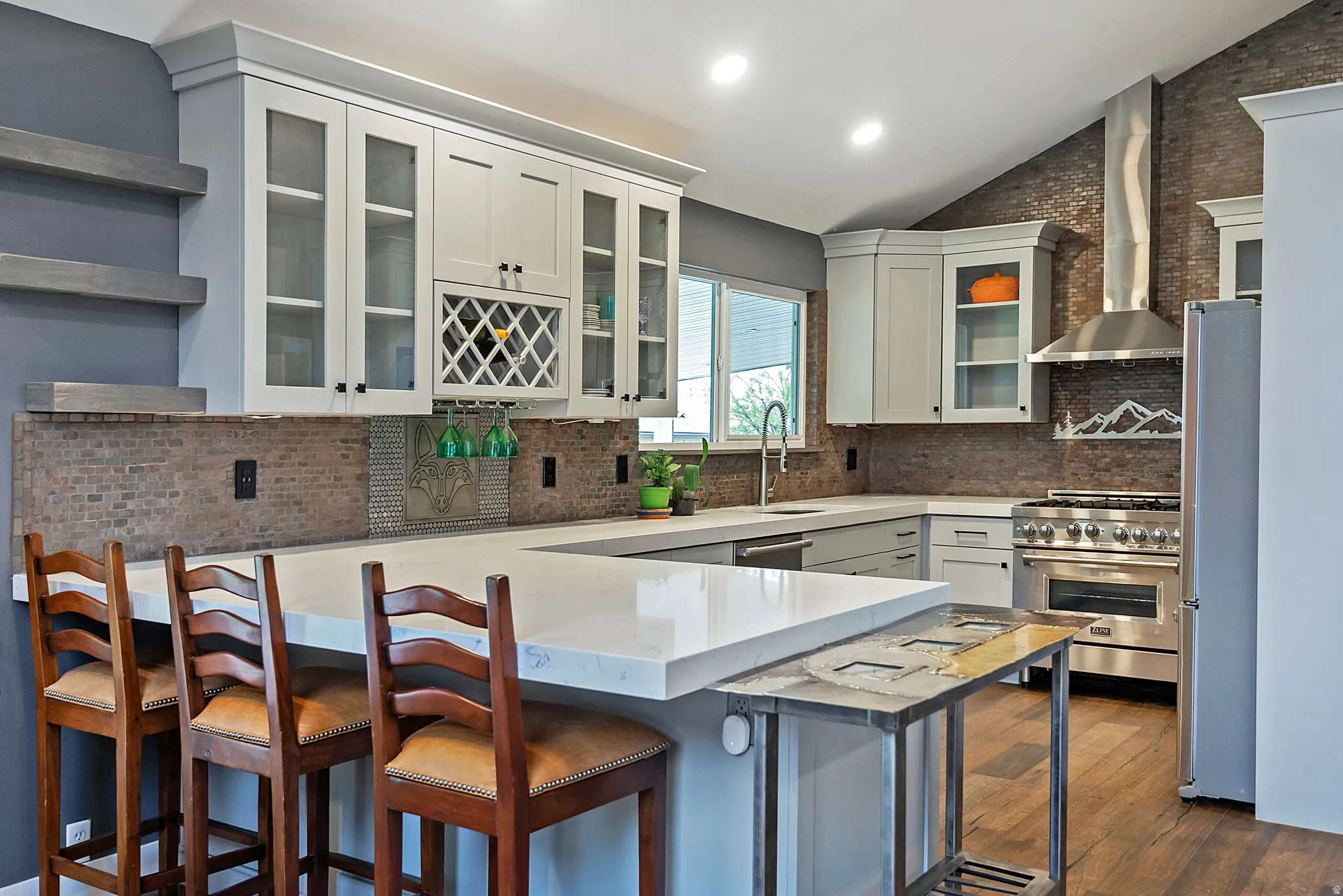 U-shaped kitchen with light-colored cabinetry, integrated wine storage, and a mosaic tile backsplash