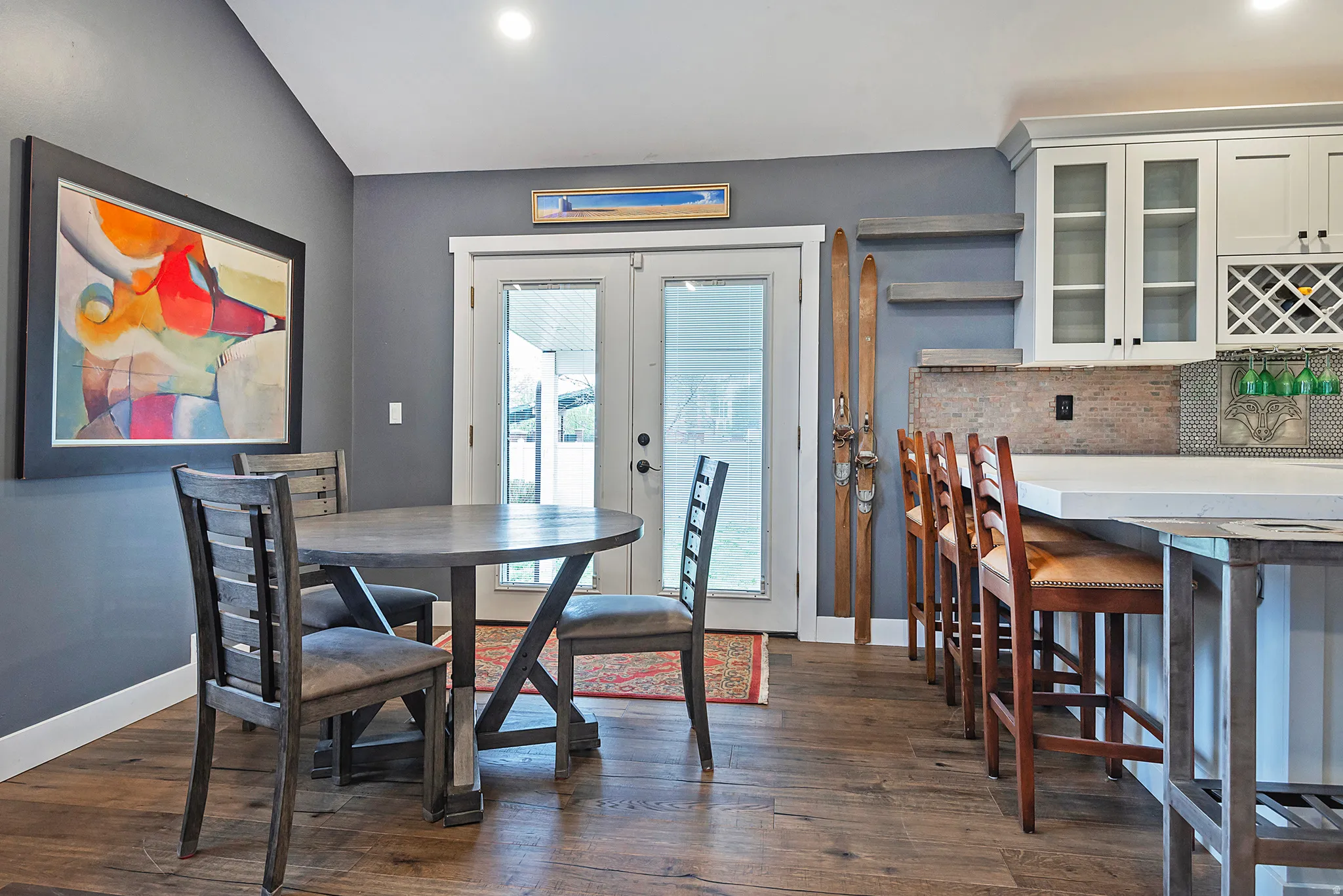 Wood-finish flooring, French doors, built-in kitchen cabinetry, built-in wine rack, and a breakfast bar