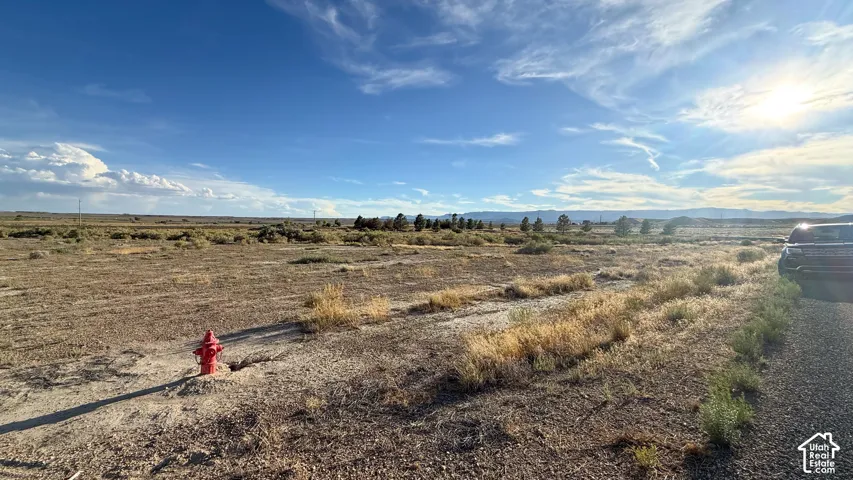 Expansive land parcel with distant mountain ranges and a fire hydrant