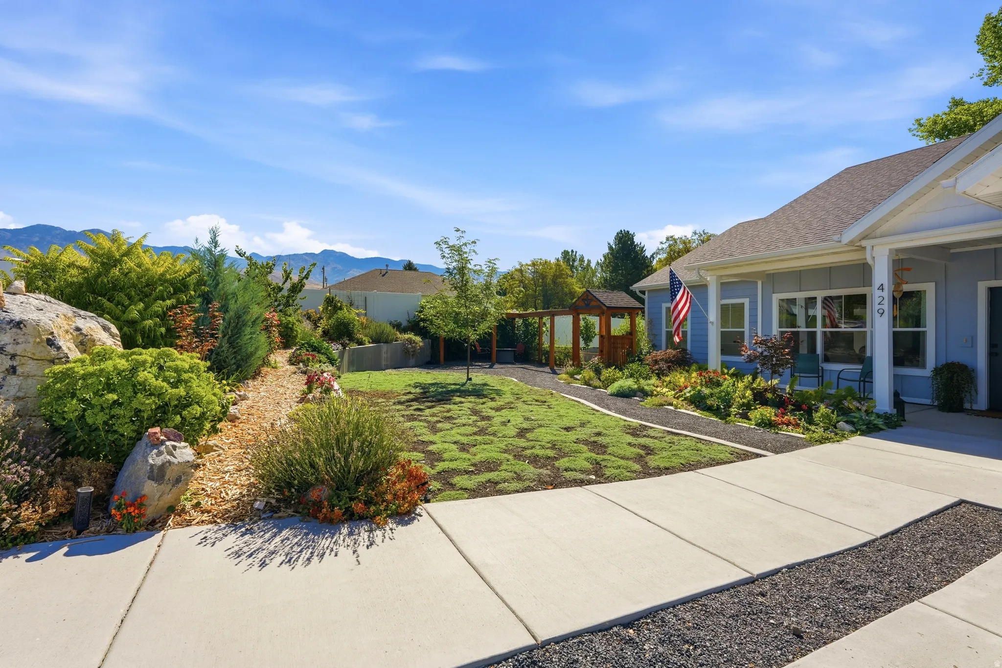 Well-maintained landscaping with decorative rocks, mature shrubs, and a distinct patterned lawn