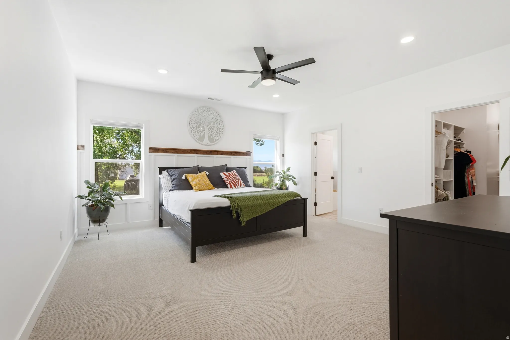 White interior walls, recessed lighting, ceiling fan, carpeted flooring, and built-in closet organization