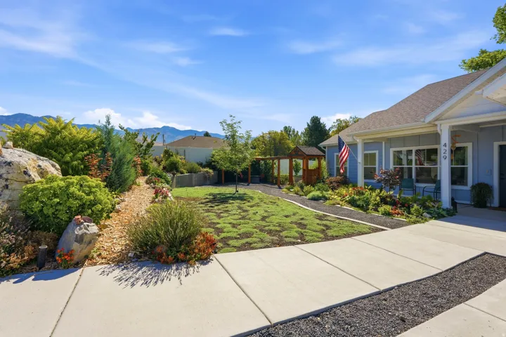 Well-maintained landscaping with decorative rocks, mature shrubs, and a distinct patterned lawn