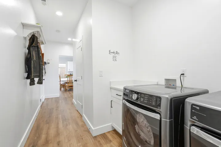 Hallway with wood-finish flooring, recessed lighting, white walls, and a built-in shelf with hooks