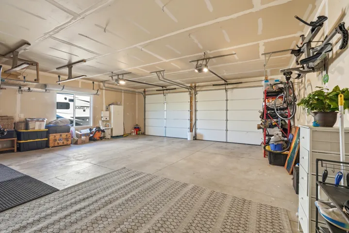 Two-car garage featuring a concrete floor, two sectional garage doors, and overhead lighting