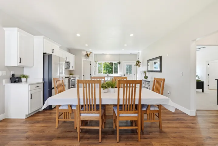 Contemporary kitchen featuring white cabinetry, stainless steel appliances, recessed lighting, and wood-finish flooring