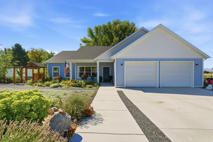 Light blue exterior with white trim, a two-car garage, a concrete driveway, and a front walkway