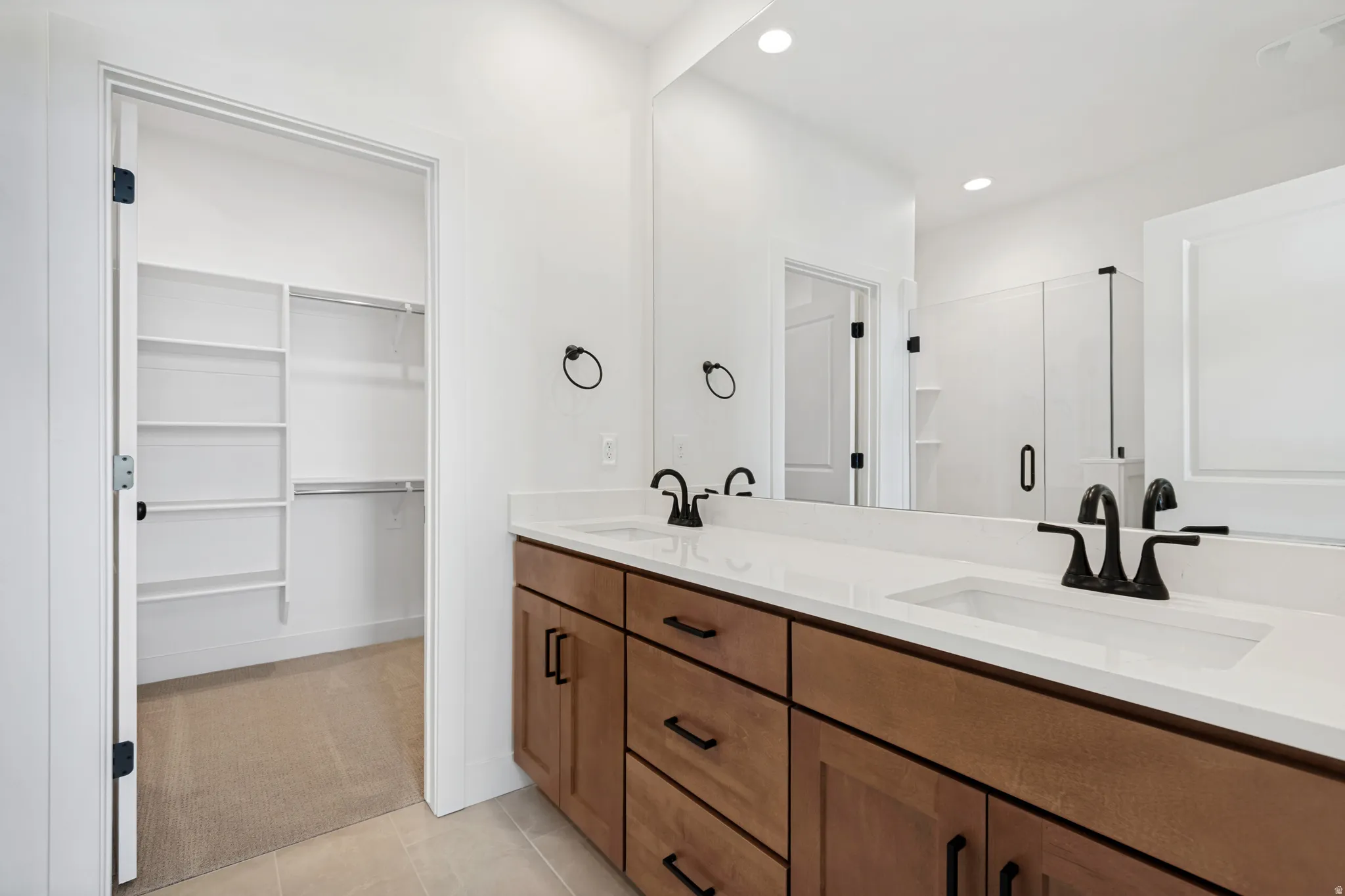 Double vanity with white countertop, undermount sinks, and matte black fixtures