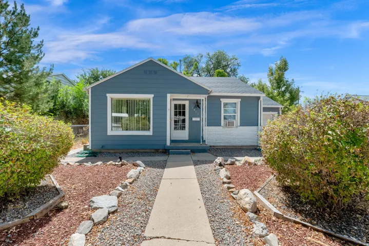 Light blue siding exterior with white trim, a white front door, and a concrete pathway