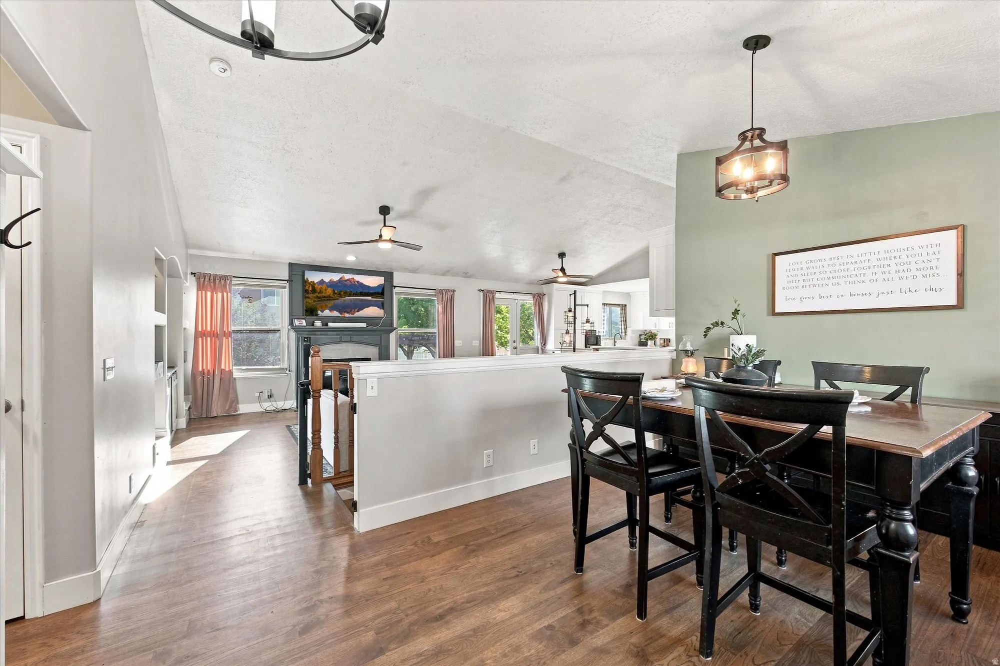Vaulted ceiling, wood-finish flooring, recessed lighting, and a decorative fireplace with mantel