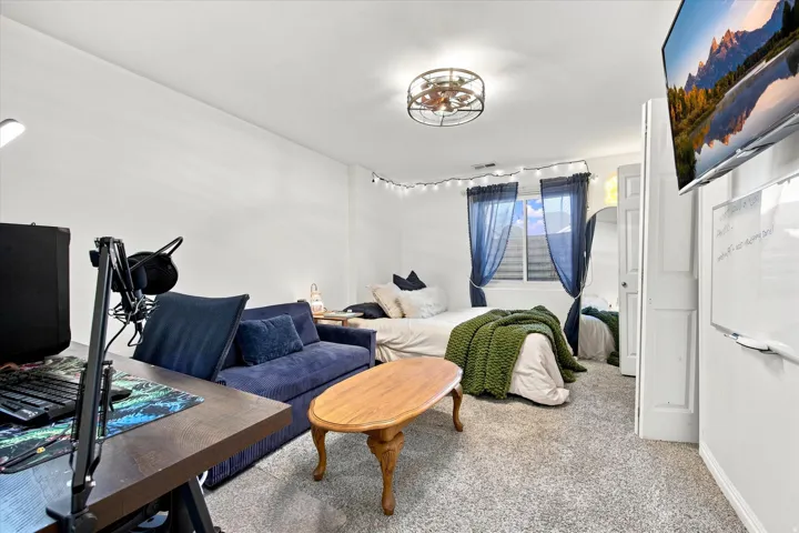 Recessed window with privacy blinds, textured wall-to-wall carpeting, and a built-in overhead light fixture